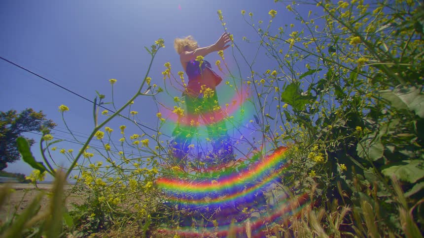 Blonde woman dancing outdoors in daylight