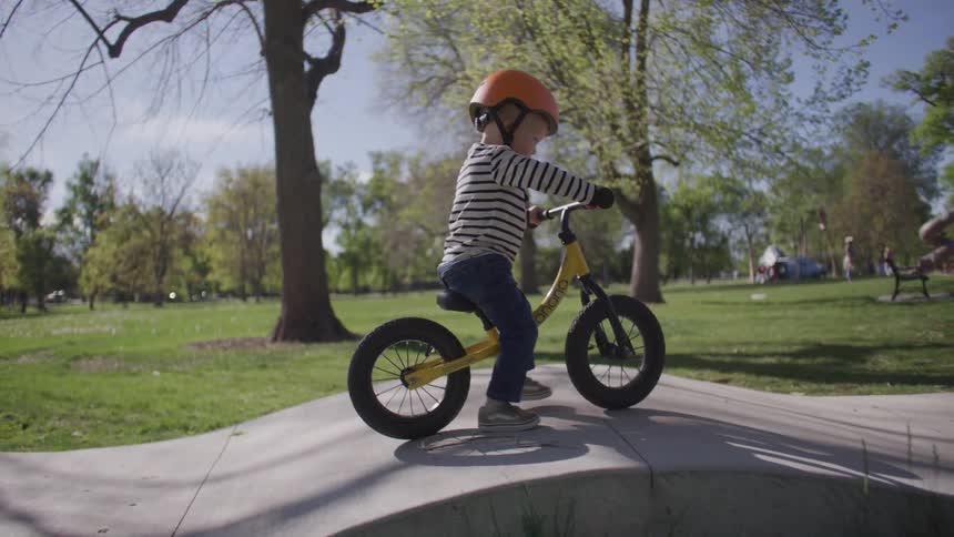 A child is riding his bicycle in the park