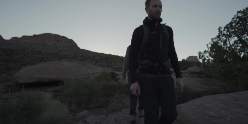 A man and woman are hiking at dusk