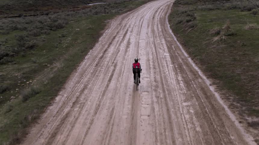 Person riding a bike over a muddy path
