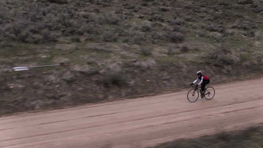 Person riding bicycle on dirt road