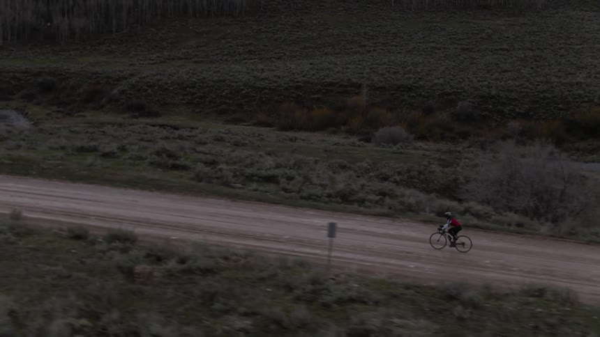 Aerial view of a cyclist riding along a country road