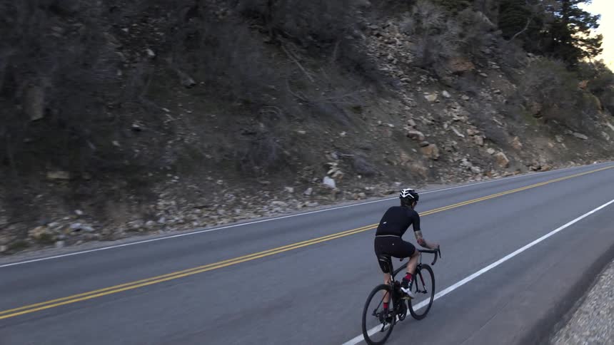 Man riding a bicycle up a highway