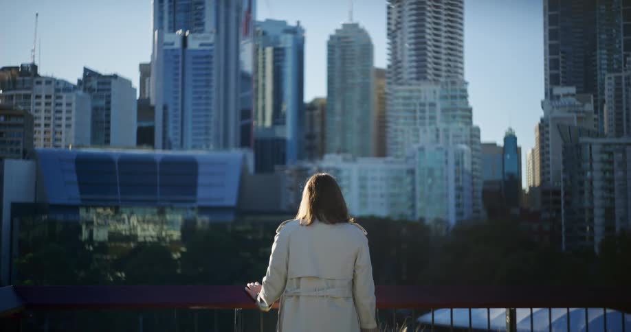 View of a woman from the back observing a metropolis with large buildings