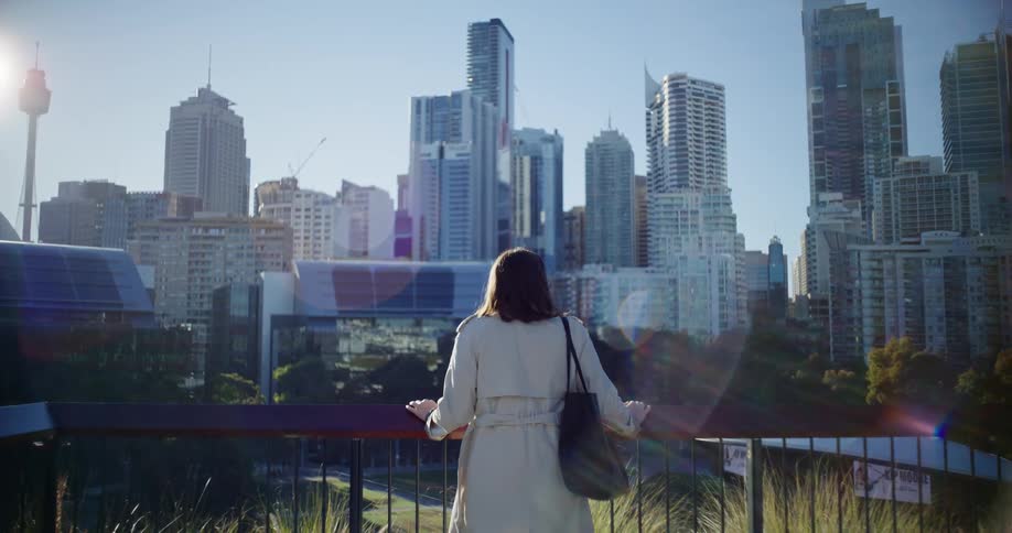 View of a woman from the back observing large buildings in a metropolis