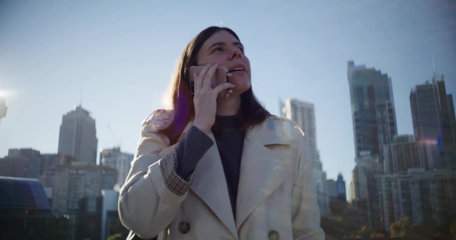 Woman on a call with her smartphone and buildings in the background of a metropolis