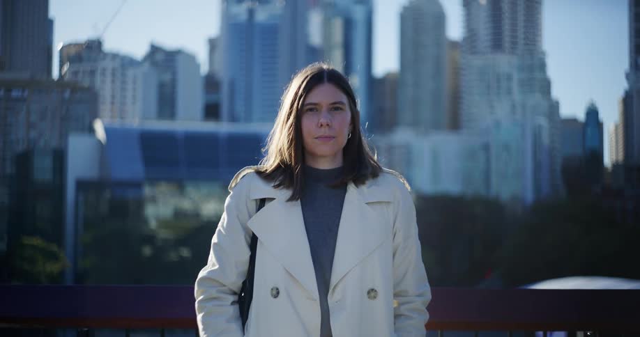 Woman wearing a white coat and buildings in the background of a metropolis