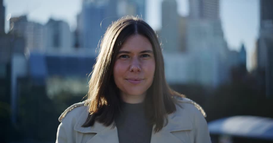 Portrait of a woman with a happy facial expression and a city in the background
