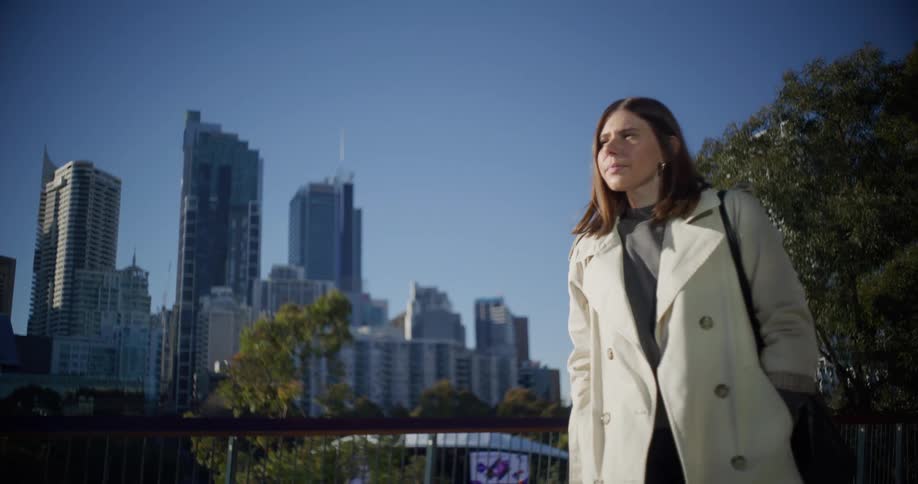 Woman walking next to buildings in a metropolis