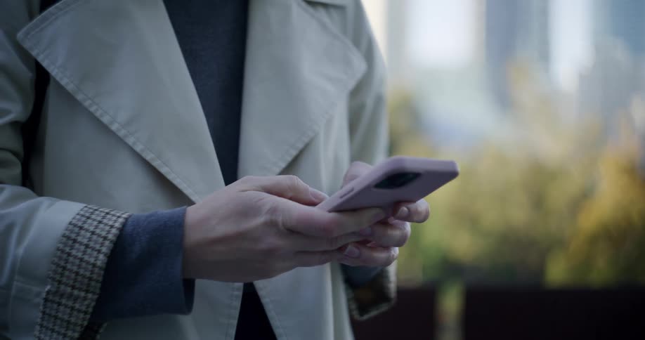 A woman is texting on her phone outside