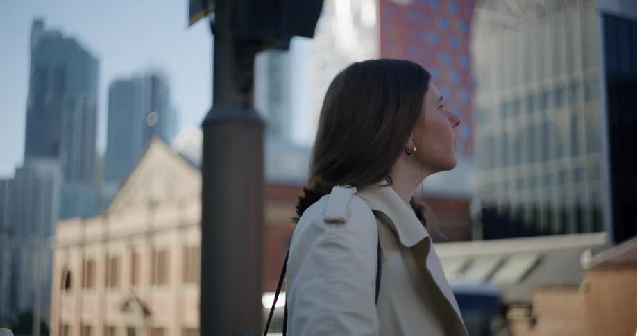A woman is in formal clothes and looking around at the buildings of a metropolitan city