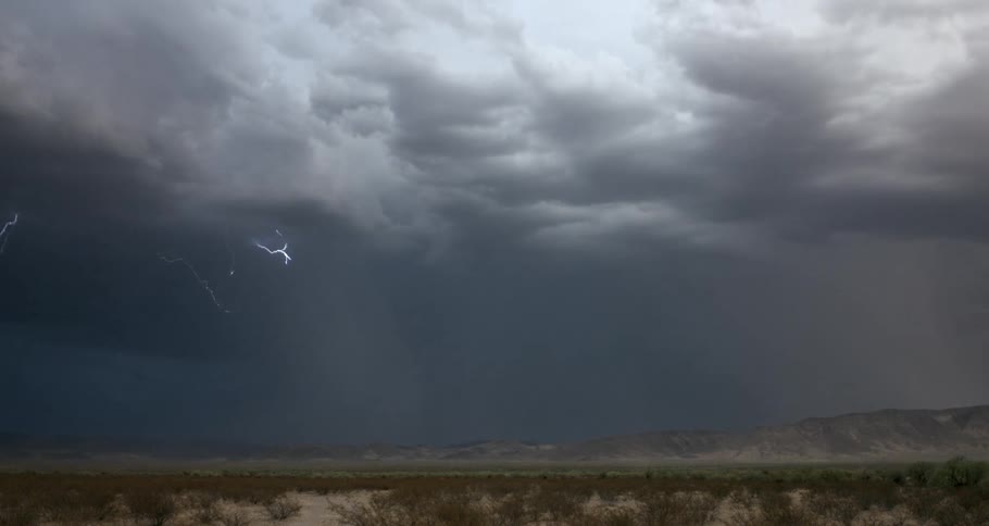Lightning storm over the desert in front of the low mountains