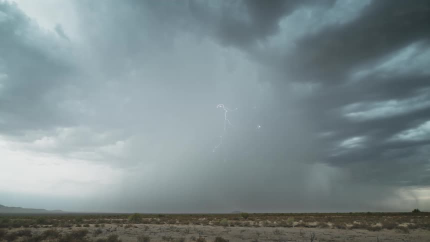 A desert landscape with several lightning strikes at its center during a storm