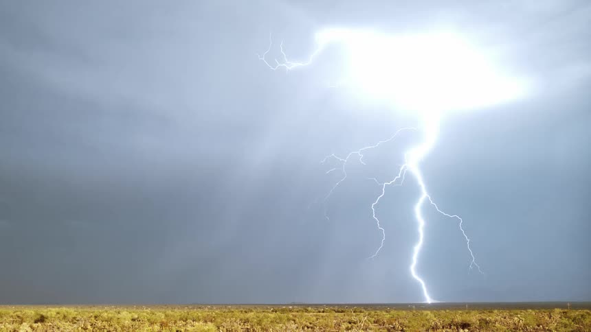 A lightning storm with gray clouds in an empty field