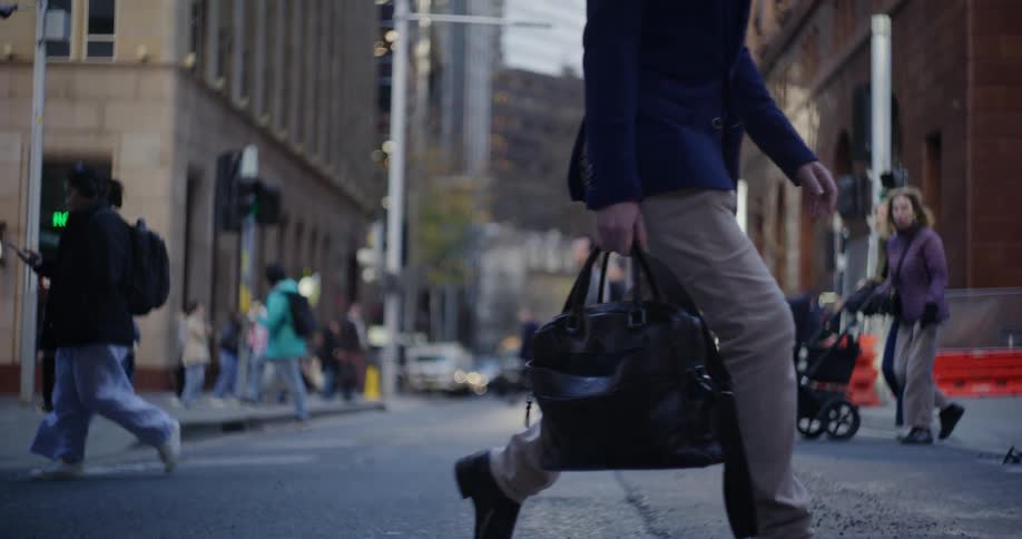 A street with some pedestrians crossing it in various directions