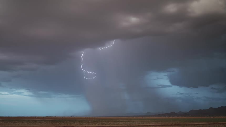 Lightning strikes the plains near the horizon during a thunderstorm