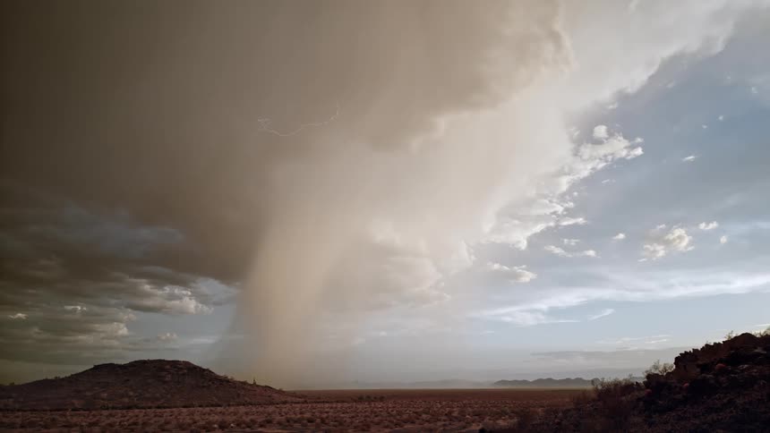 Landscape of mountains in a desert environment and a sky with thunder