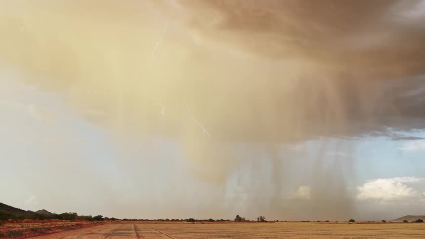 A dramatic thunderstorm with lightning strikes the plains in daylight