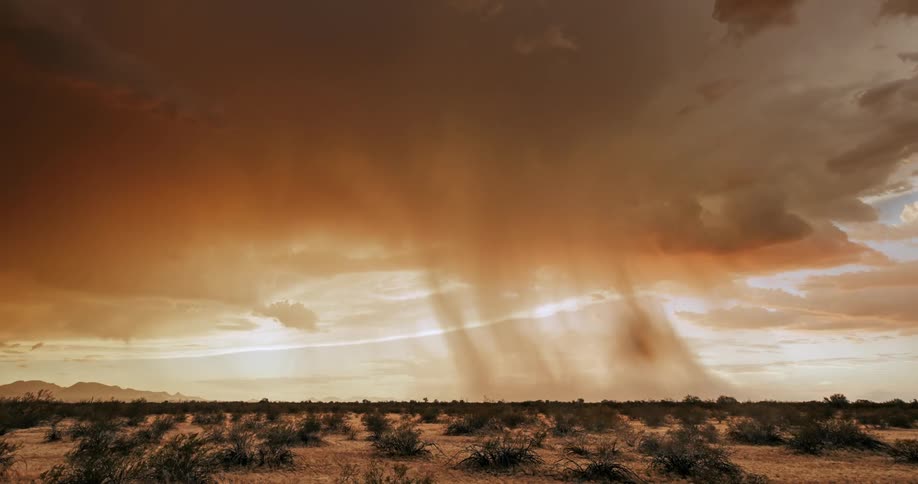 A time lapse shows a thunderstorm pass above a dry landscape with spare vegetation