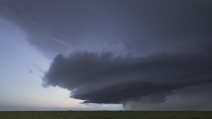 A huge black storm cloud with several lightning bolts falling to the ground