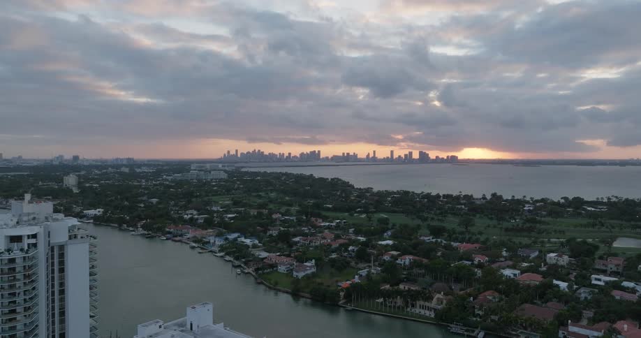 Islands with residential neighborhoods surrounded by the sea and a metropolis on the horizon with a red sky