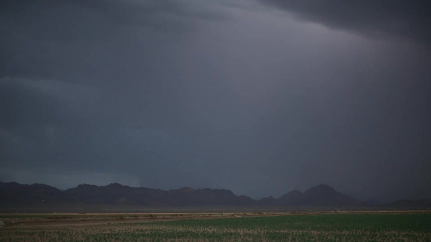 Lightning strikes the ground near the mountains in the rural countryside