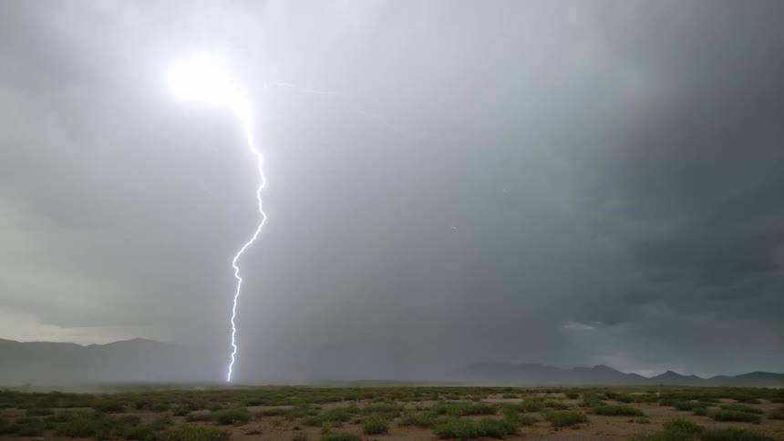 A dramatic thunderstorm with lightning strikes the plains in daylight