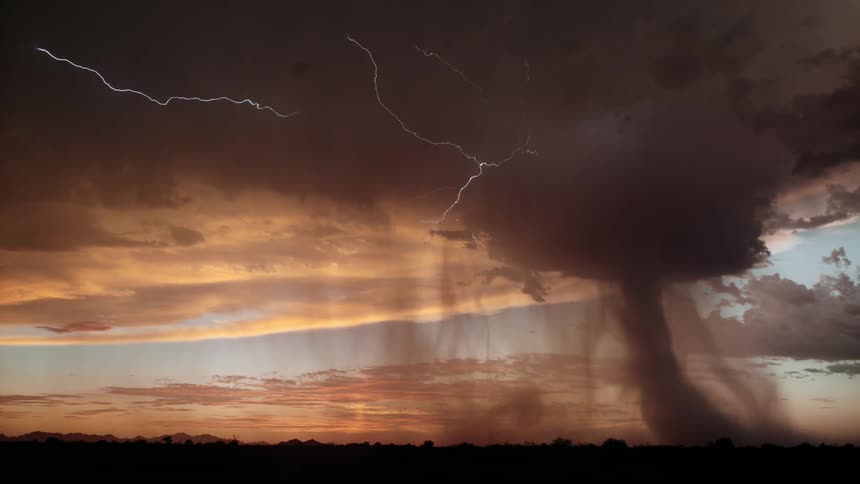 Chain lightning spreads through the storm clouds as it rains