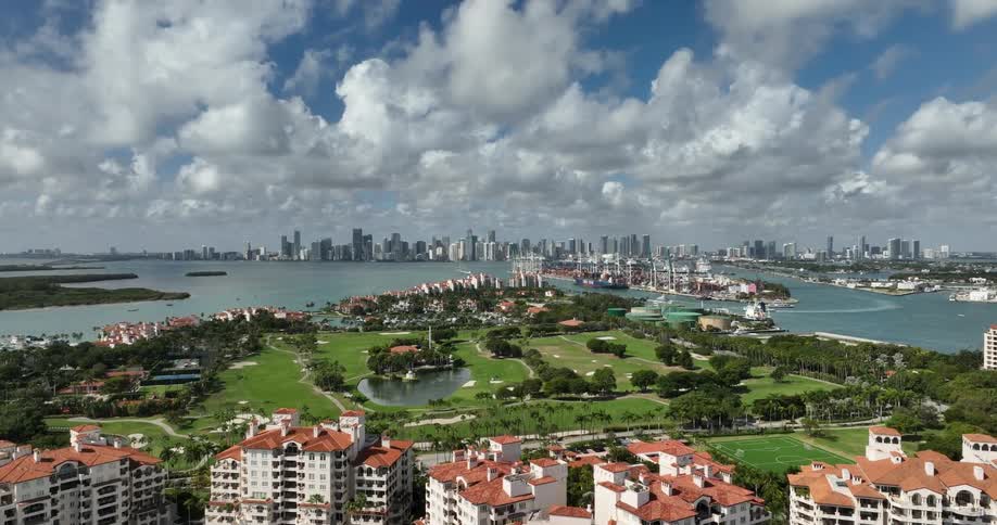 Aerial panorama of a resort surrounded by a turquoise sea in a metropolis with a skyscraper on the horizon
