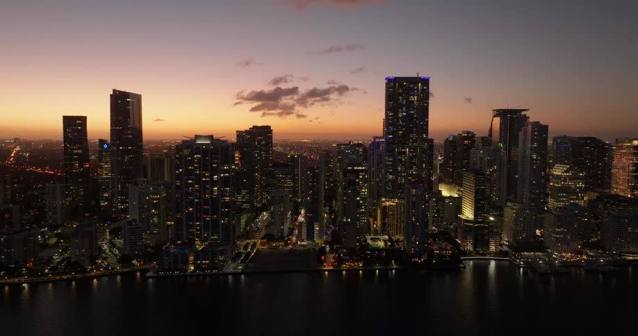 Aerial scenery of illuminated metropolises at night with reddish sky