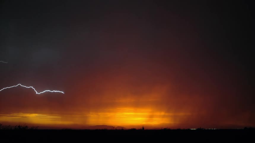 Dark sky with orange tones and bright rays of lightning