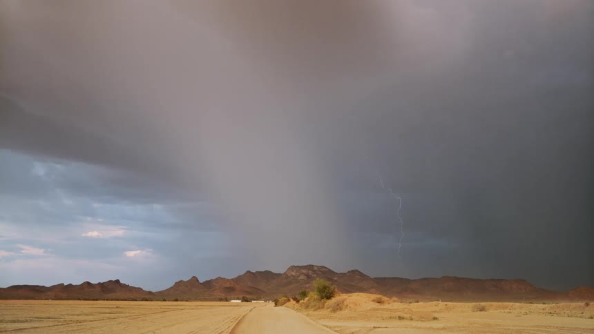 Storm with lightning above mountains in a desert location