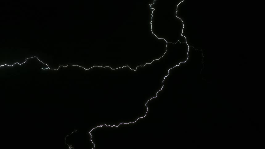 A jagged lightning bolt during a storm against a dark sky shooting downwards into the night