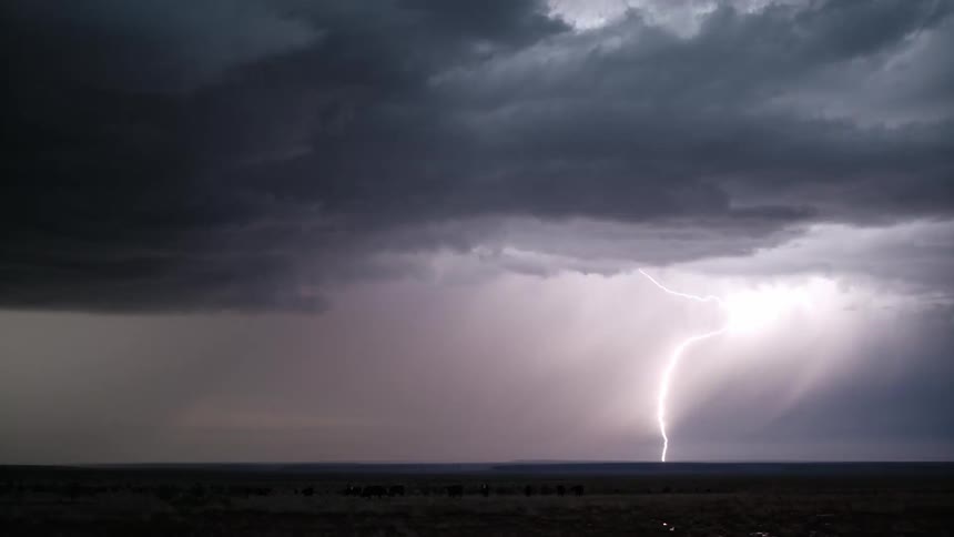 Vast field against a dark sky with lightning