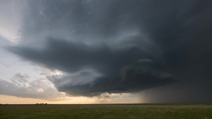 A time lapse of dark sprawling storm clouds rolling over a vast landscape