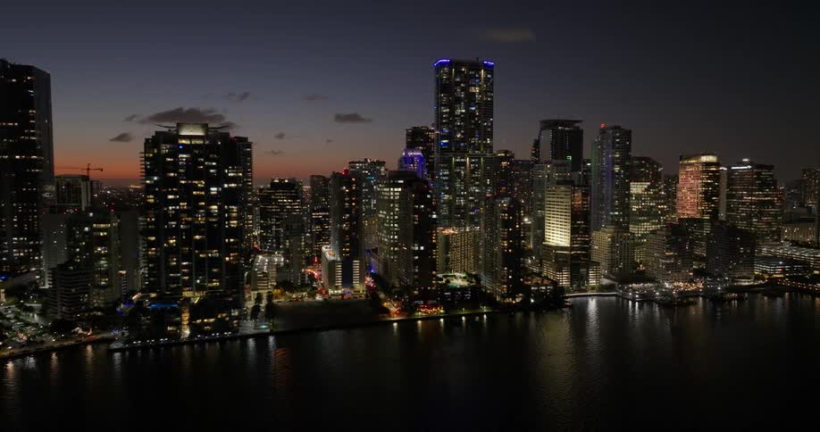 Tall buildings line the shore at sunset
