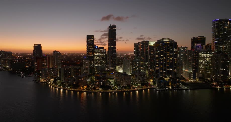 Still waters reflect the lights of the downtown buildings on the curving waterfront at night