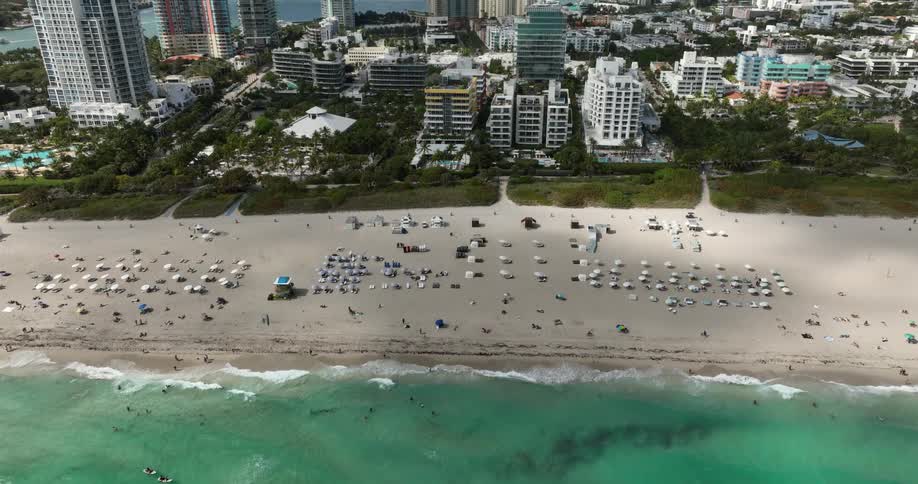 Aerial scene of a turquoise sea and the coast full of modern buildings in a metropolis