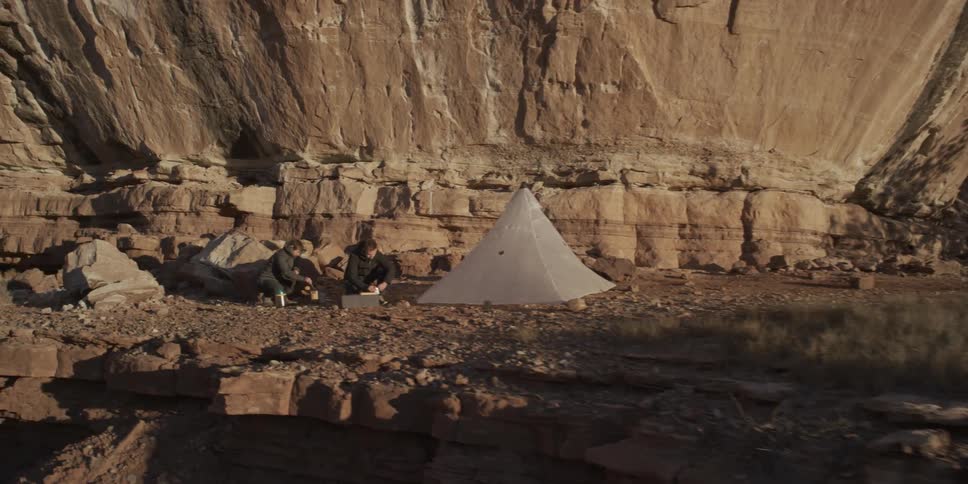 People are sitting by their camp on the canyon