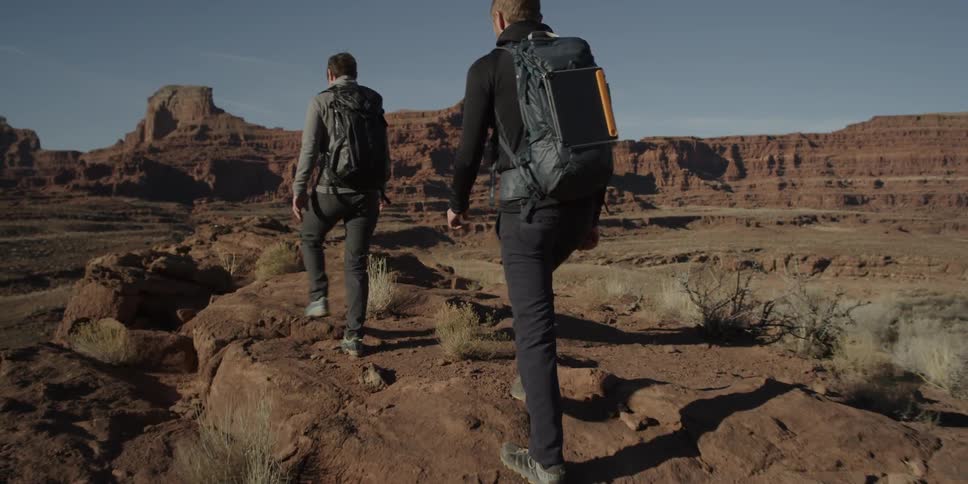 Two people hike a rocky ridge