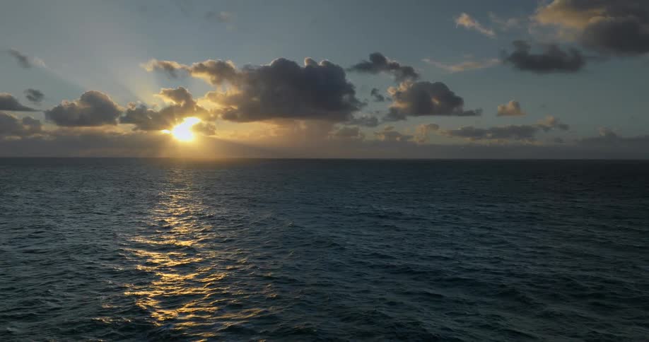 Landscape of a vast ocean with sun on the horizon
