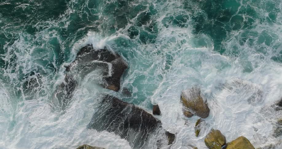A coast with several rocks and some small waves hitting them