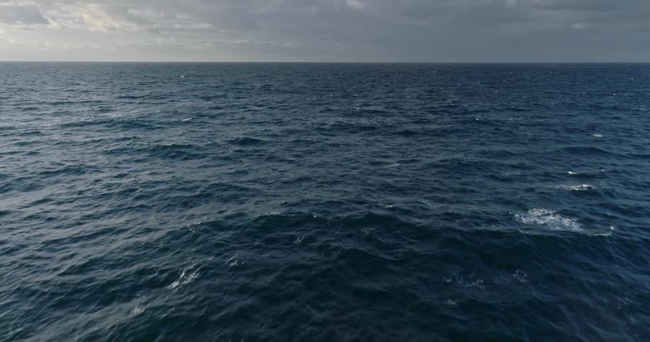 An aerial view of of the ocean or sea on a cloudy day