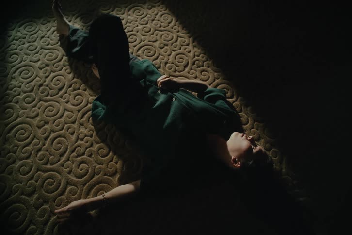 Man lying on the floor inside a room with reflected sunlight