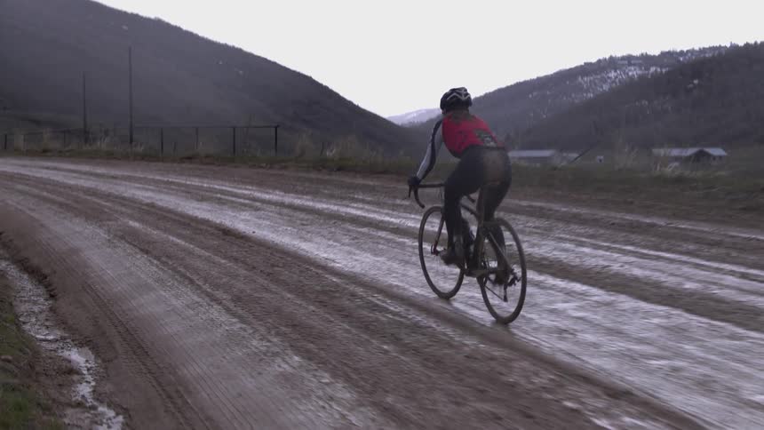 Person riding a bike over a muddy path