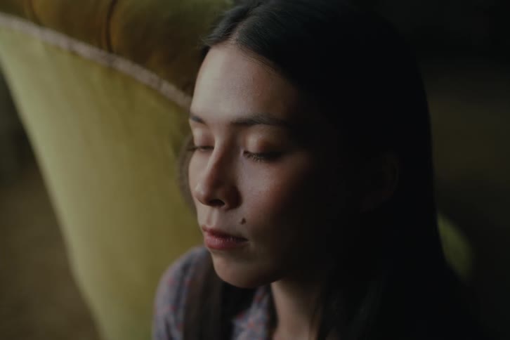 Portrait of a woman sitting indoors and running her hand through her hair
