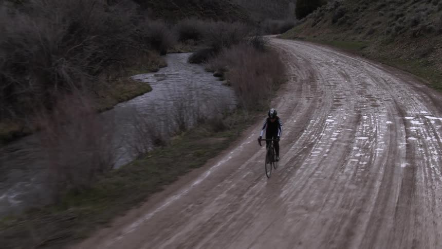 The man below is mountain biking on a dirt trail
