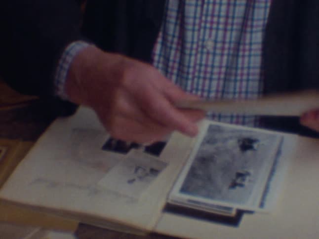 A person is going through some papers and he is wearing a suit