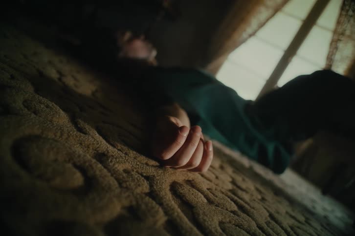 Woman lying on a rug moving one of her hands