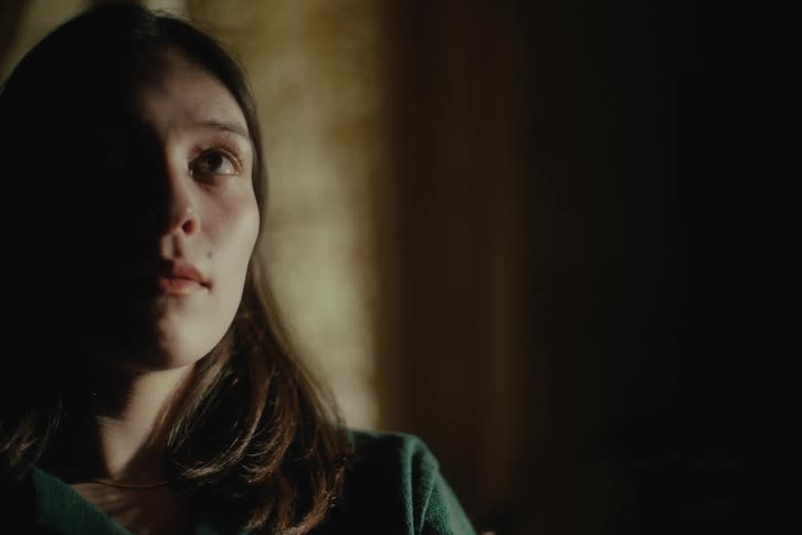 A face of a young woman that is partially dark